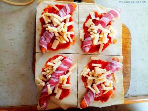 Wiener Würstchen im Speckmantel mit Tomatensugo und Käse in Blätterteig - Remoulins – France
